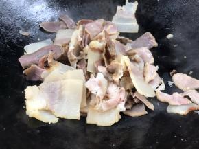 另起锅，放腊肉煎炒出油至微黄色