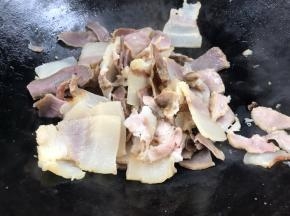 另起锅，放腊肉煎炒出油至微黄色