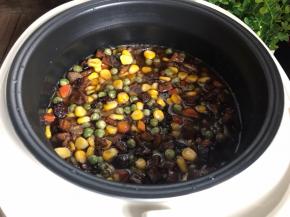 再把炒好的腊肉倒入上面，盖好盖子，插上电源按煮饭键即可