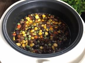 再把炒好的腊肉倒入上面，盖好盖子，插上电源按煮饭键即可