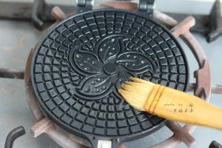 蛋卷模具上下两面都刷一层薄薄的色拉油，然后燃气灶小火两面各预热1分钟