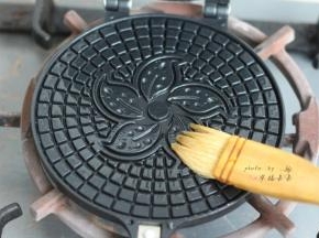 蛋卷模具上下两面都刷一层薄薄的色拉油，然后燃气灶小火两面各预热1分钟
