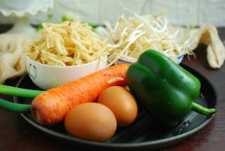 准备好所有的食材。1根胡萝卜，500克饼丝，300克绿豆芽，1个青椒，2个鸡蛋。我做的是两人份，如果人多请加量。