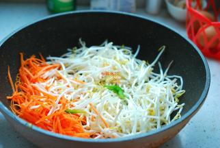 炒锅刷洗干净，另放油烧热，下入2个大料炸出香味，接着下入葱花煸炒出香味，先下胡萝卜丝，翻炒几下，再下绿豆芽，翻炒均匀。