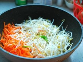 炒锅刷洗干净，另放油烧热，下入2个大料炸出香味，接着下入葱花煸炒出香味，先下胡萝卜丝，翻炒几下，再下绿豆芽，翻炒均匀。