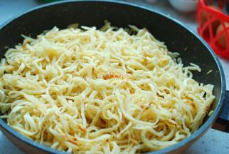 菜炒到八分熟就可以了，查看一下锅底，如果有太多的汤汁，一定要倒出去，少留一点儿就可以，汤汁太多炒出开的饼丝会发粘，不够清爽，口感太差。这时把火关到最小，然后把饼丝轻轻抖散，均匀地铺在炒好的绿豆芽上面，盖上盖子，小火焖煮8分钟左右。