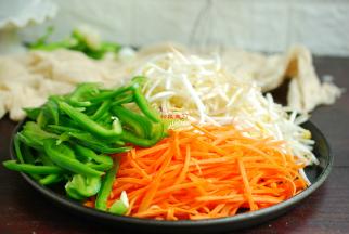 300克绿豆芽择去坏芽，去除不太好的豆芽，清洗干净，控干水分。青椒清洗干切成细丝，胡萝卜去掉皮清洗干净切成细丝。