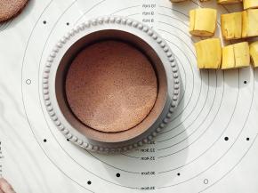 香蕉先不去皮，切成4CM的小段备用。取一个6寸的慕斯圈放在一个盘子上，慕斯圈的内壁放一圈慕斯围边(便于脱模，没有也可以不放）。取一片蛋糕片放在里面。