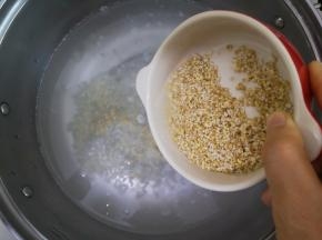 2、锅中倒入清水开火，将清洗过的燕麦粒和胚芽米倒入锅中。