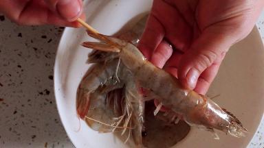 搅拌均匀后，将大虾插上竹签