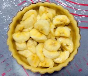 香蕉切片，加柠檬汁搅拌均匀，放入派盘