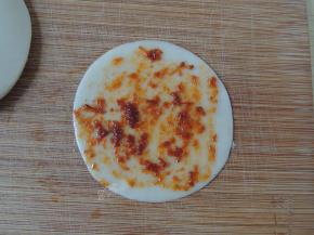 然后刷一层烧烤酱。如果没有烧烤酱的话，也可以撒盐、胡椒粉、孜然粉等调味料。家里有什么就用什么吧，我有一次直接把中午烧的梅干菜肉挖了一大勺，剁碎一些就可以用了，类似梅干菜饼的味道。