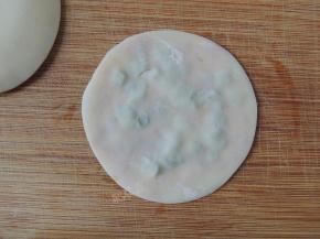 再取一块饺子皮盖在葱花上面，我用稍微按压一下，让两片饺子皮贴合在一起。