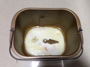 将牛奶、蛋液、糖、盐、玉米油加入到面包机内胆中