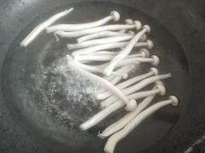 再把锅里做水烧开，下白玉菇焯水两分钟左右，捞出来过一遍凉开水
