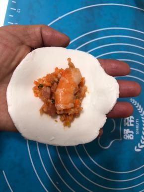 包上拌好的馅料，每个饺子里放一个虾段。