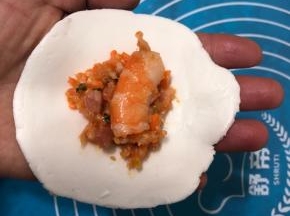 包上拌好的馅料，每个饺子里放一个虾段。