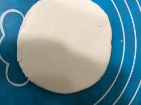 案板上刷点油，菜刀一面也抹掉油，用刀压成如图的饺子皮形状，然后用刀把饺子皮铲下来。第一次用刀压，压得还不太行，需要多加练习。