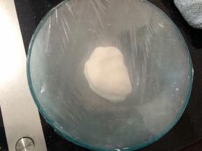 5分钟后用手给它揉成光滑的面团，盖上保鲜膜醒发20分钟左右。