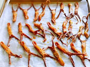 将鸭舌用筷子夹到垫有油纸的烤盘中，依次摆放好。