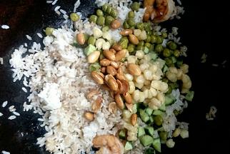 加入黄瓜丁、玉米粒、豌豆粒，花生米翻炒均匀