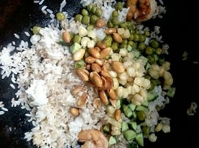 加入黄瓜丁、玉米粒、豌豆粒，花生米翻炒均匀