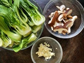 油菜摘去老的叶子，冲洗干净，然后对半切开，香菇也洗干净切成片，蒜头剥皮后剁碎备用；取一个干净的碗，放入适量耗油和淀粉，再加适量水化开。