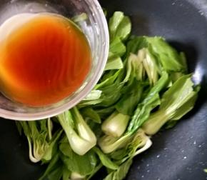 热锅凉油，下一半蒜蓉，煸炒出香味后加入油菜，大火快速翻炒片刻，然后倒入一半调好的汁。