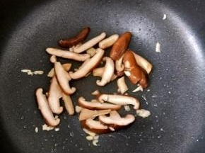 锅重新烧热，放适量花生油，再放入蒜蓉和香菇，翻炒均匀。