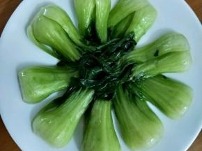 把刚才炒好的油菜摆一圈，尽量叶子全部摆在里面，根部朝外面。