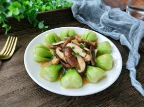 然后把香菇盛在油菜中间，再淋上刚才焖香菇的汁，最后撒点葱花，完成。