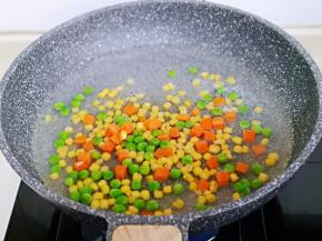 将玉米粒，胡萝卜丁，豌豆焯水，水烧开，下入煮2分钟，捞出淋干水分。