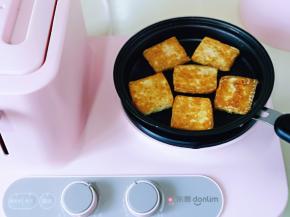 中小档将豆腐煎至金黄，再翻一面，两面都煎至金黄即可。