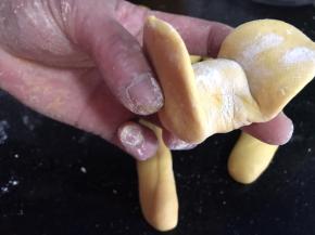 拿起面条，如图，把两头的边边捏一起