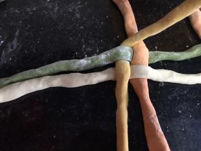 把底下一条拿起来压住旁边上面的一条，我从黄色开始压住红色面条