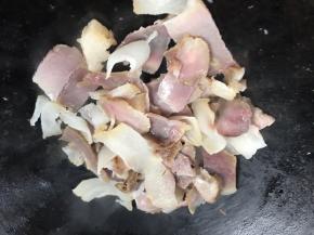 另起锅，倒入腊肉煎炒至出油，表面微黄