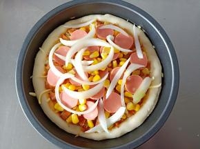 依次铺上烤好的鱼片，玉米粒，火腿肠，玉米粒，洋葱丝