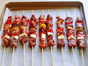 烤盘垫上油纸，将串好的牛肉串放入烤盘中。