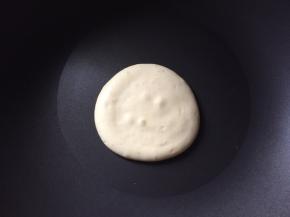 将面糊装入裱花袋，挤入不粘锅中，或者用勺子舀入不粘锅