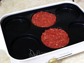 OSTINI多功能料理锅的六圆盘薄薄刷一层油，把牛肉团分成2等份，在六圆盘中团圆压扁。