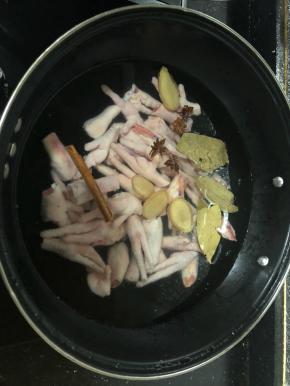 锅里加水倒入鸡爪，加入姜片，料酒，香料，八角等大火煮。