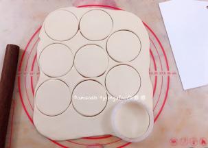 松弛好的面团擀开擀簿，然后用饺子模把面皮按压出来