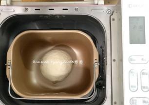 揉成光滑的面团，揉圆放在面包机中，盖上盖子松弛20分钟