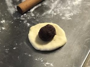 松弛后每份面团都擀成圆皮，然后放入一份红豆馅。