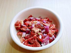 切好的牛肉放入器具中，加入切好的洋葱，用手抓拌均匀。