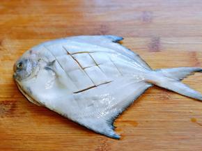 洗干净的金鲳鱼背上切花刀。