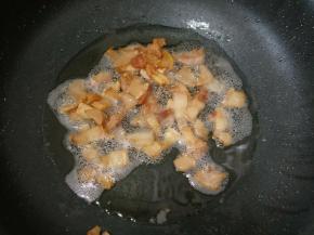 接着放肥猪肉进去慢慢炒至出油，倒出多余的油。