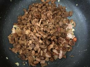 大火翻炒至猪肉变色。然后倒入萝卜干，转中火炒一分钟左右。