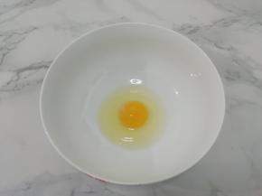 鸡蛋打入碗中，用手动打蛋器搅拌均匀