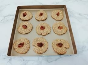 在用手按扁，在饼干的中间用手按一下，在放上葡萄干，放入提前预热好的烤箱中，中层170度，烤20分钟